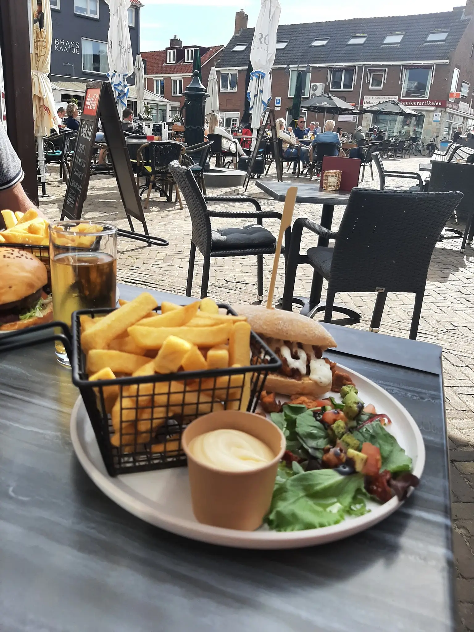 Bordje met friet en hamburger op het terras van Bij Brigitte