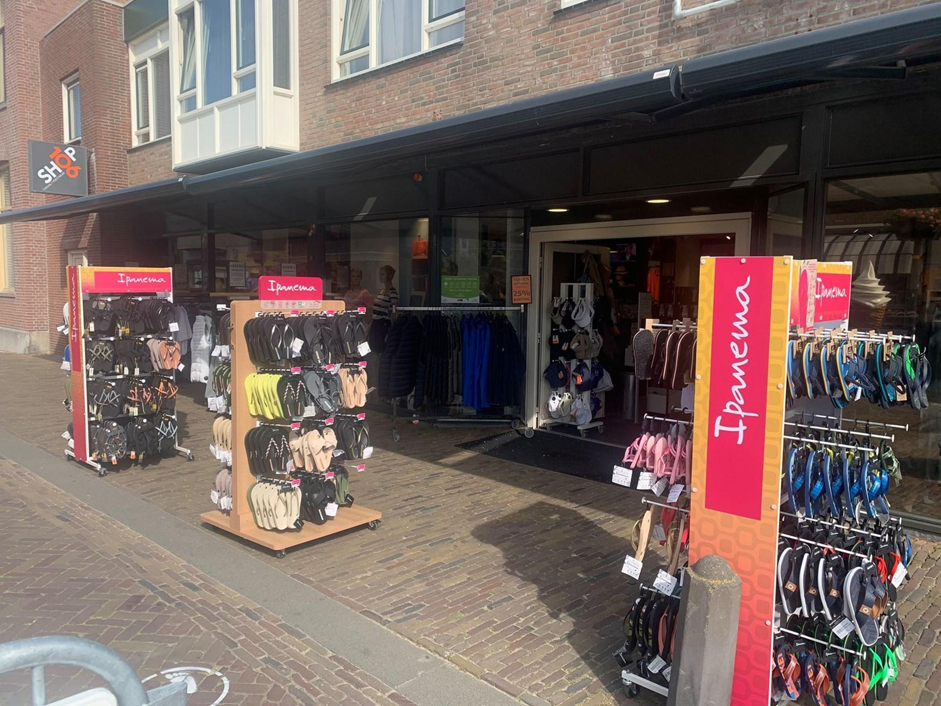 Buitenkant van Shop 106 met rekken met slippers