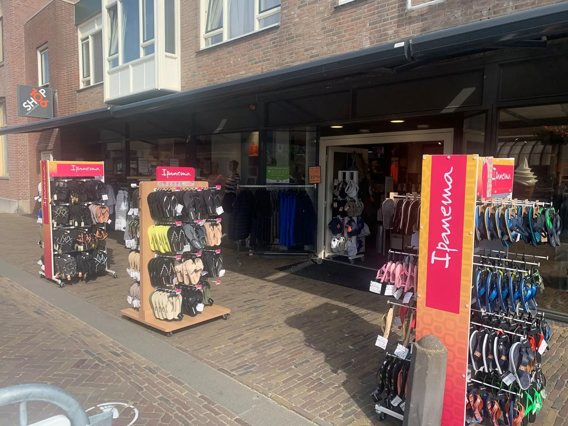 Buitenkant van Shop 106 met rekken met slippers