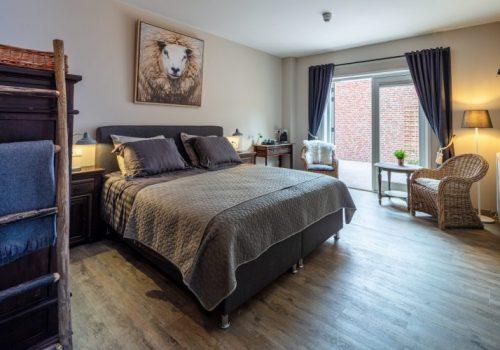 Kamer in Herberg Binnen met tweepersoons bed en een zitje