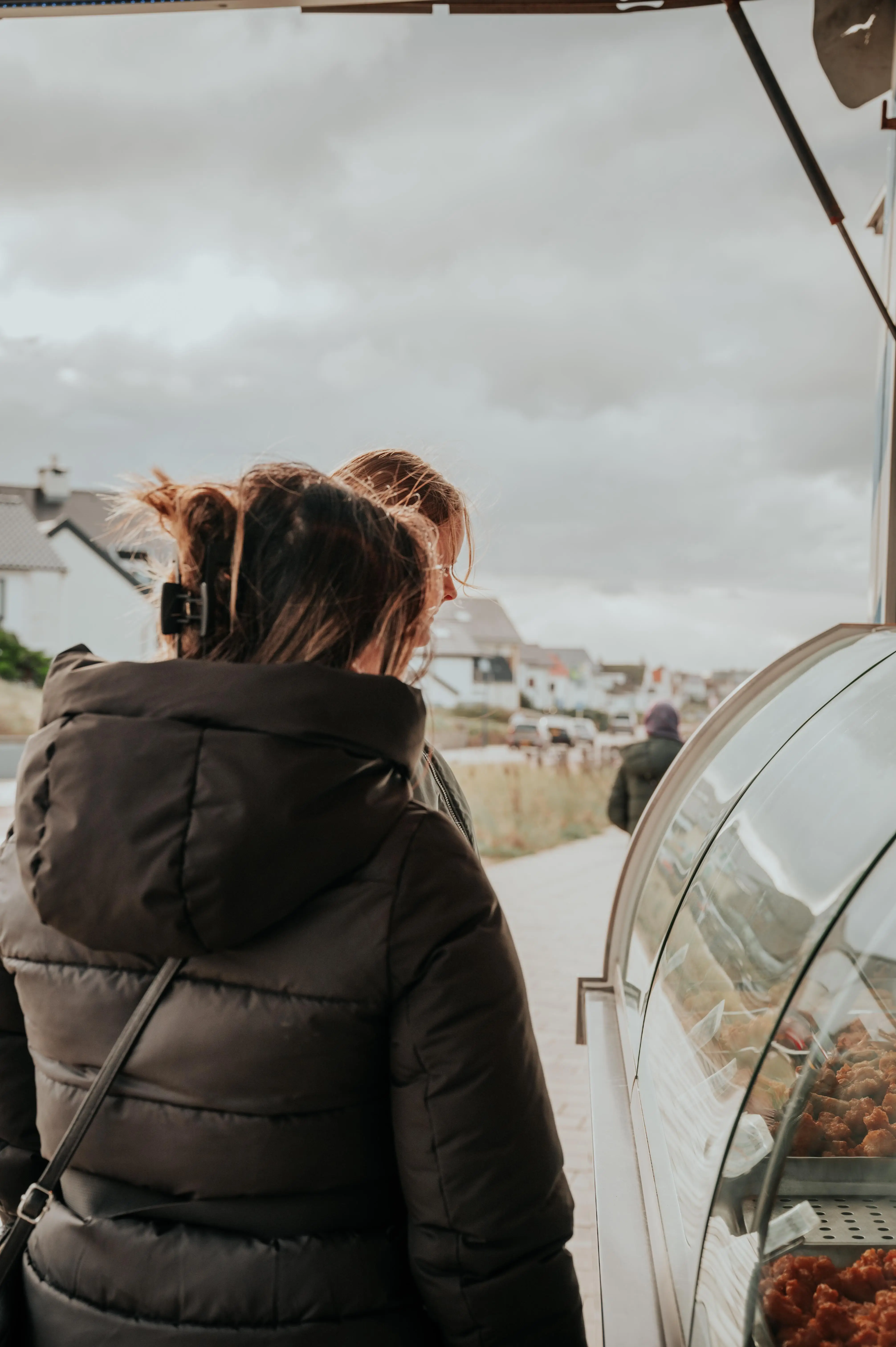 Twee vrouwen staat te kijken bij de vitrine van viskar Kroon