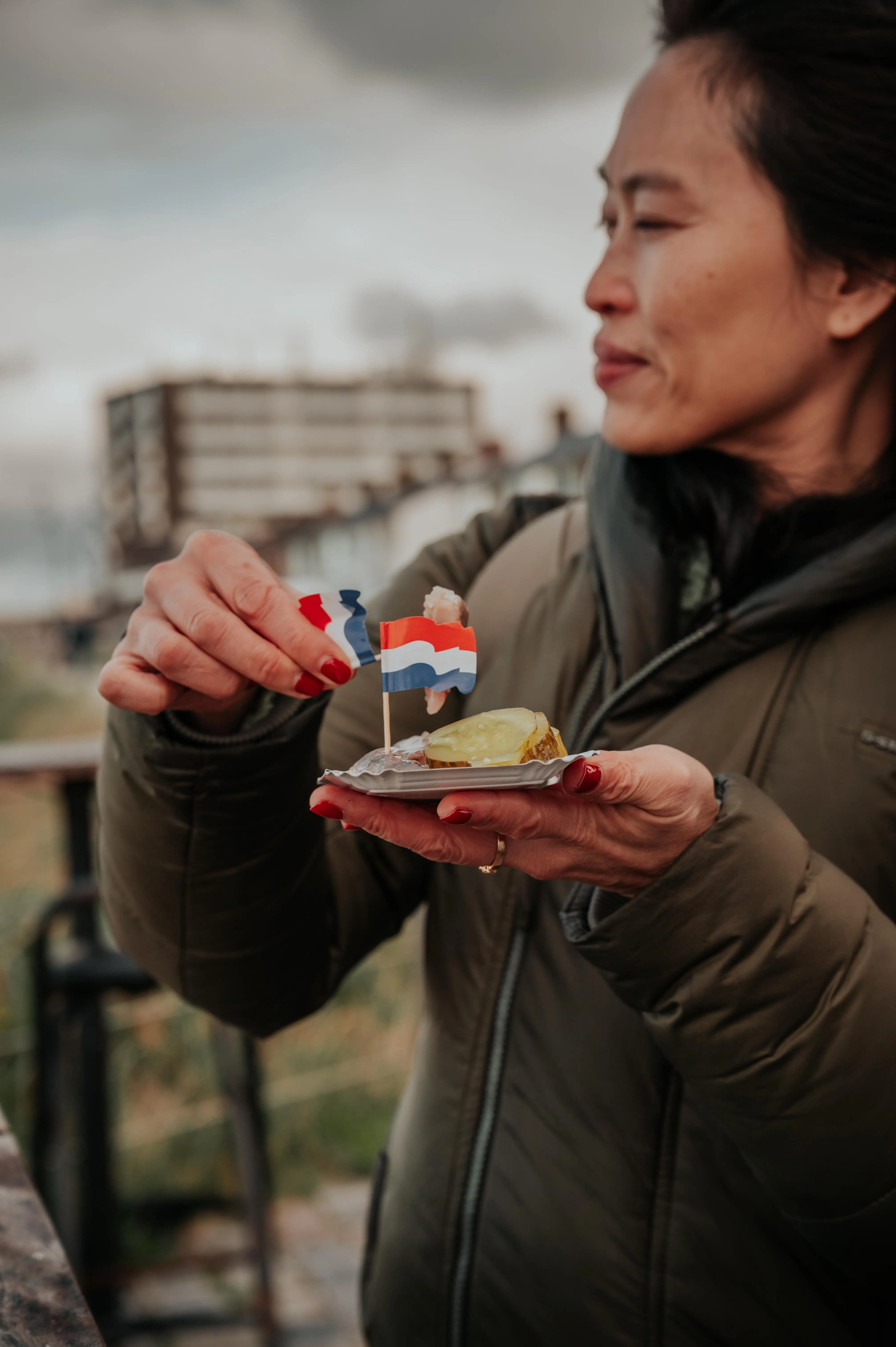 Vrouw eet een haring op de boulevard