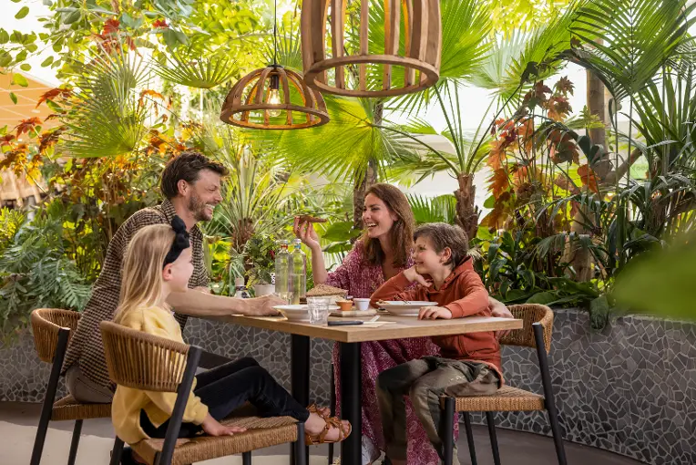 Gezin etend aan tafel in the market dome van center parcs park zandvoort