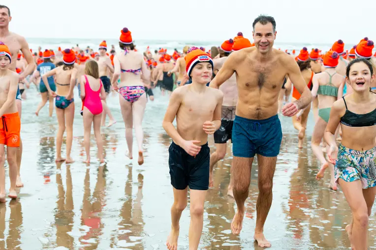 Vader en zoon rennen de zee uit na de nieuwjaarsduik.