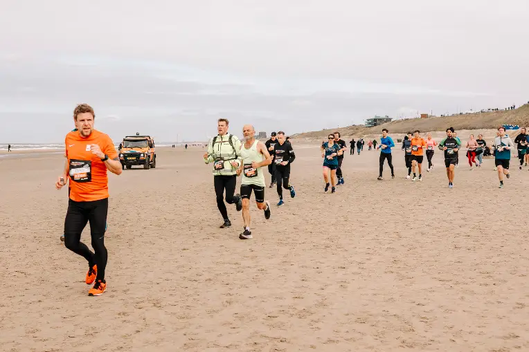 Hardlopers rennen op het strand tijdens de Circuit Run
