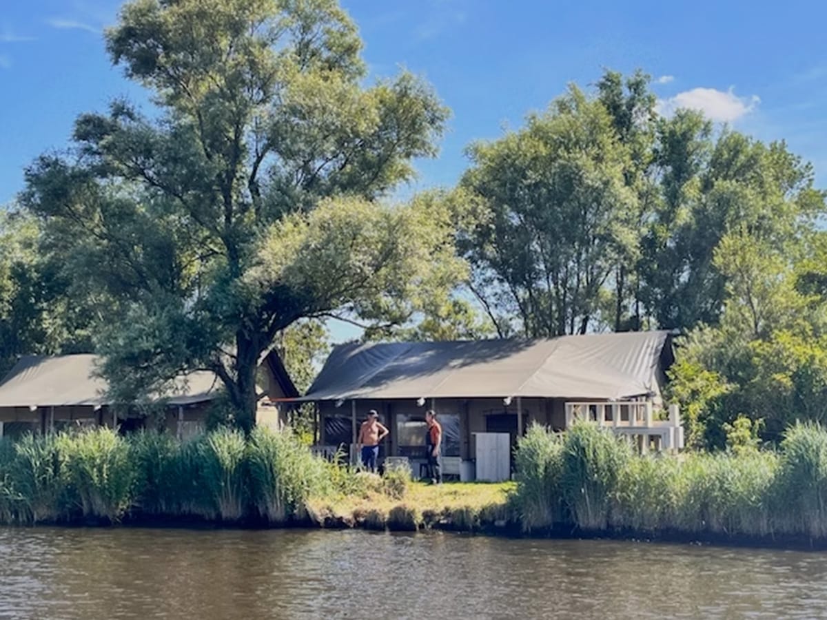 Zicht op glaming tenten vanaf het water