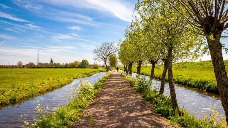 Wandelaar aan het wandelen langs water in Norod-Holland